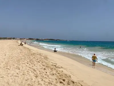 a group of people walking on the beach at Greenland Tropical in Santa Maria