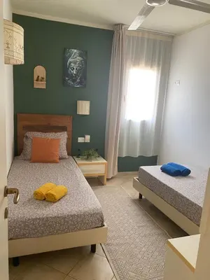 a bedroom with two beds and a window at Greenland Tropical in Santa Maria
