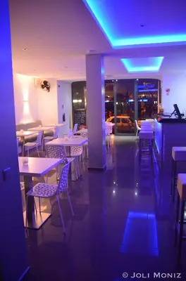 a restaurant with tables and chairs and purple lights at Prassa 3 Boutique Hotel in Mindelo