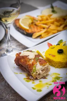 a plate with a piece of food and a glass of wine at Prassa 3 Boutique Hotel in Mindelo