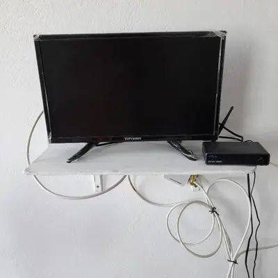 a flat screen tv on a white shelf at Santos Medina in Ribeira Grande