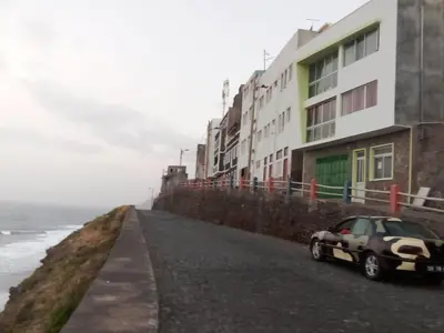 a car parked on the side of a road next to the ocean at Santos Medina in Ribeira Grande