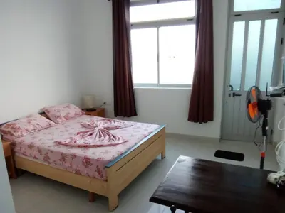 a bedroom with a bed and a table and a window at Santos Medina in Ribeira Grande