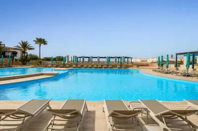 a large swimming pool with lounge chairs in a resort at Barceló Marine Boa Vista - Adults Only in Sal Rei