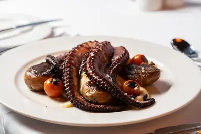 a plate of food with sausage and tomatoes on a table at Barceló Marine Boa Vista - Adults Only in Sal Rei