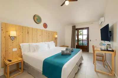 a bedroom with a large bed and a television at Barceló Marine Boa Vista - Adults Only in Sal Rei