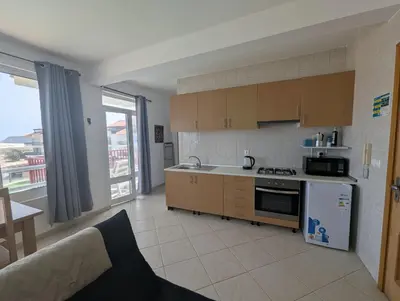 a kitchen with a stove and a couch in a room at Vila Cabral 2 Apartments - AC in Sal Rei
