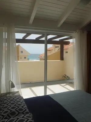 a bedroom with a view of the ocean at Vila Cabral 2 Apartments - AC in Sal Rei