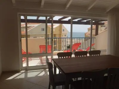 a dining room with a table and a view of the ocean at Vila Cabral 2 Apartments - AC in Sal Rei
