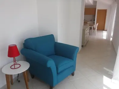 a blue chair and a table with a red lamp at Vila Cabral 2 Apartments - AC in Sal Rei