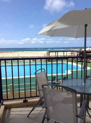 a patio with a table and chairs and the beach at Vila Cabral 2 Apartments - AC in Sal Rei