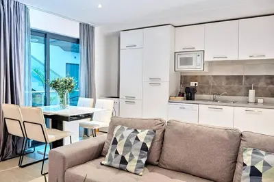 a kitchen and living room with a couch and a table at Apartamento Ap3 T1 Santa Maria Residence in Santa Maria
