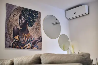 a living room with two mirrors and a painting on the wall at Apartamento Ap3 T1 Santa Maria Residence in Santa Maria