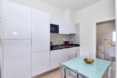 a kitchen with white cabinets and a blue table at Apartamento Praia Santa Maria in Santa Maria