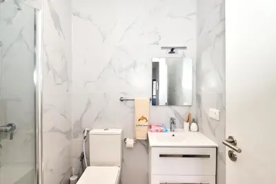 a white bathroom with a toilet and a sink at Apartamento Praia Santa Maria in Santa Maria