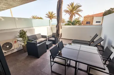 a balcony with a table and chairs on a roof at Apartamento Praia Santa Maria in Santa Maria