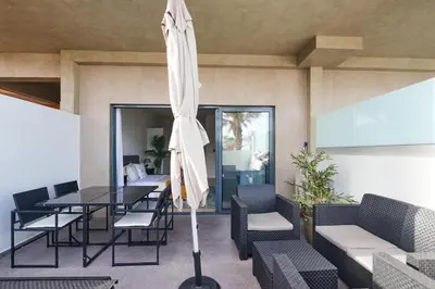 a patio with a table and an umbrella at Apartamento Praia Santa Maria in Santa Maria