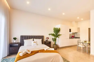 a bedroom with a large bed and a kitchen at Apartamento Praia Santa Maria in Santa Maria