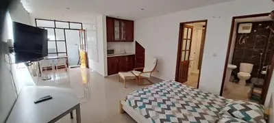 a room with a bed and a living room with a kitchen at Studio Cruz Espia in Mindelo