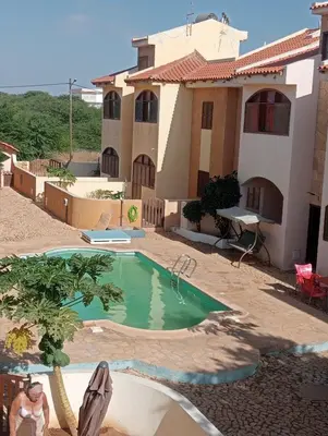 a villa with a swimming pool in front of a house at Holiday Maio in Calheta Do Maio