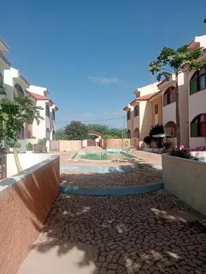 a courtyard with a pool inbetween two buildings at Holiday Maio in Calheta Do Maio
