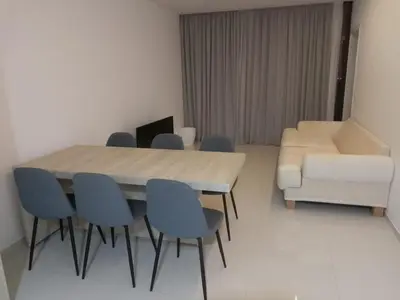 a dining room with a table and chairs and a couch at Apartamento in Mindelo