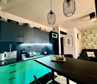 a kitchen with green cabinets and a black counter top at Tropical Manera in Santa Maria