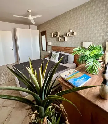 a living room with a couch and a table with a plant at Tropical Manera in Santa Maria