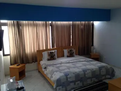 a bedroom with a large bed with a blue ceiling at LT Aparthotel in Praia