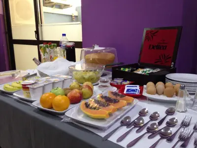 a table topped with plates of fruit and other food at LT Aparthotel in Praia