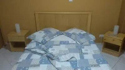 a bed with a blue and white quilt on it at LT Aparthotel in Praia