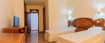 a hotel room with two beds and a television at Residencial Cosmos in Assomada