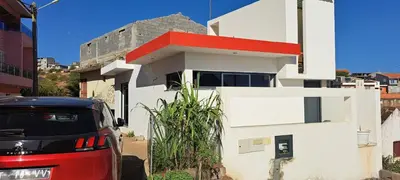 a car parked in front of a white house at Liminha Guest House in Calheta de São Miguel
