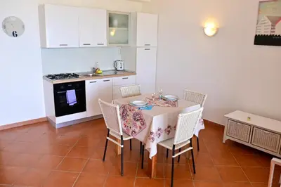 a kitchen with a table with chairs and a stove at Porto Antigo II Ocean Appartment in Santa Maria