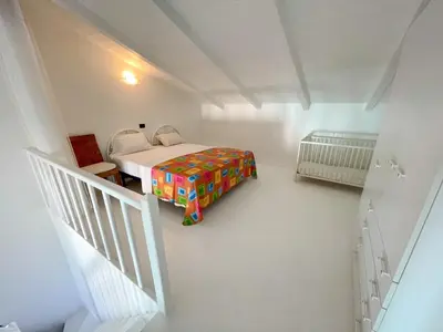 a small bedroom with a bed and a staircase at Porto Antigo II Poolside Appartment in Santa Maria