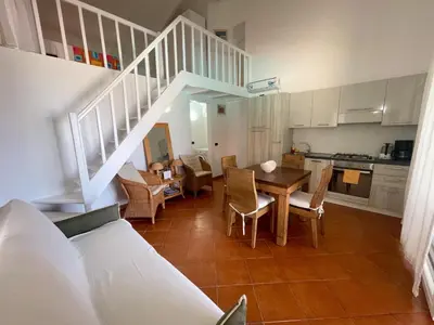 a kitchen and dining room with a table and stairs at Porto Antigo II Poolside Appartment in Santa Maria