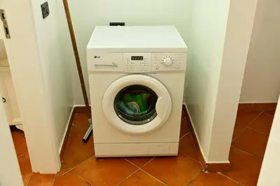 a washing machine with its door open in a room at Porto Antigo II Poolside Appartment in Santa Maria