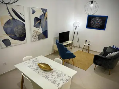 a living room with a table and chairs and paintings at Tarrafal Bay - 1Bdr Apt - 3 in Tarrafal