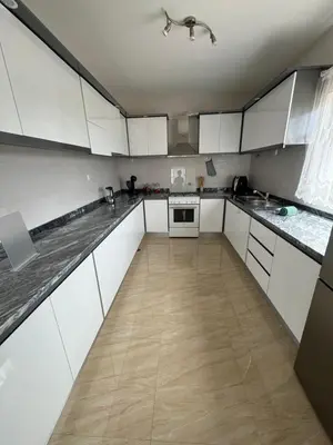 a large kitchen with white cabinets and a wooden floor at Casa Carveiros Panoramic 360 in Tarrafal