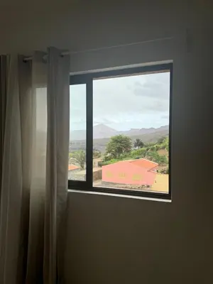 a window with a view of a building at Casa Carveiros Panoramic 360 in Tarrafal