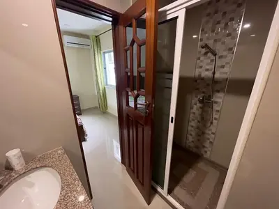 a bathroom with a shower with a sink and a mirror at Suites Home Tarrafal in Tarrafal