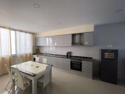 a kitchen with a table and a table and chairs at Suites Home Tarrafal in Tarrafal