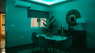 a dining room with green walls and a table with chairs at Prainha Beach Apartment I in Praia