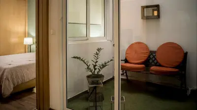 a room with a chair and a bed and a window at Prainha Beach Apartment I in Praia