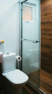 a bathroom with a toilet and a glass shower at Prainha Beach Apartment I in Praia