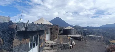 a stone building with a pyramid in the background at Casa Mamã in Portela