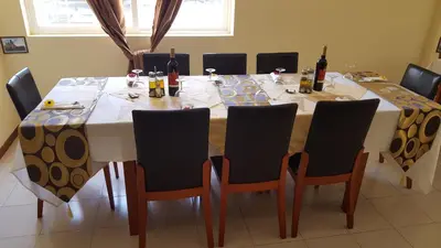 a large table with chairs and bottles of wine on it at Hotel Lazareto in Mindelo