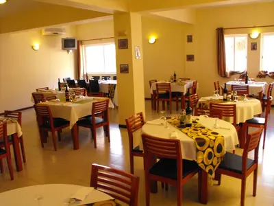 a dining room with tables and chairs in a restaurant at Hotel Lazareto in Mindelo