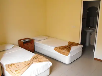 a room with two beds and a sink in it at Hotel Lazareto in Mindelo