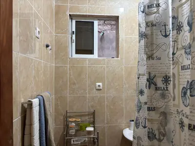 a bathroom with a shower and a toilet and a window at Techas Family Beach Stay 3BR in Central Tarrafal in Tarrafal